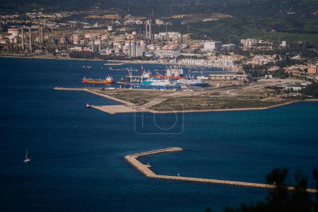 Téléchargez les photos : Gibraltar, Grande-Bretagne - 24 janvier 2024 - Vue aérienne d'un port industriel avec des cargos, un brise-lames et un voilier dans la mer. - en image libre de droit