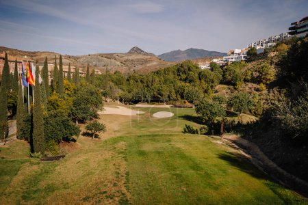 Foto de Sotogrante, España - 26 de enero de 2024 - calle de golf con bunkers de arena, banderas, árboles y montañas en el fondo. - Imagen libre de derechos