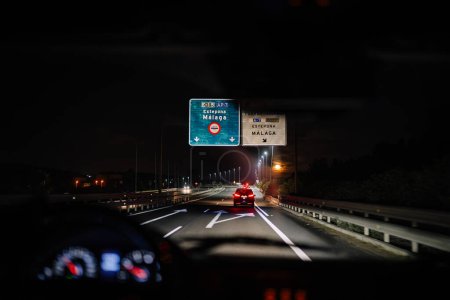 Téléchargez les photos : Sotogrante, Espagne - 27 janvier 2024 - Point de vue du conducteur sur une autoroute la nuit avec des panneaux de signalisation pour Estepona et Malaga. - en image libre de droit