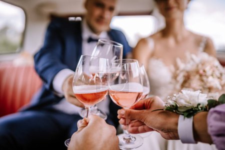 Valmiera, Latvia - July 7, 2023 - Four people are toasting with glasses of rose wine in a celebratory manner, likely at a wedding