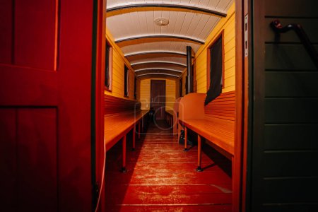 Riga, Latvia - February 16, 2024 - interior of an old train car with wooden benches and a curved ceiling, warmly lit.