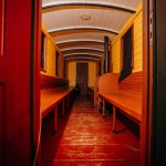 Riga, Latvia - February 16, 2024 - interior of an old train car with wooden benches and a curved ceiling, warmly lit.