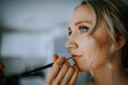 Riga, Lettland - 20. Januar 2024 - eine Nahaufnahme einer Frau, die ihre Lippen mit einem Pinsel schminkt