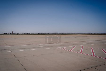 Agadir, Marruecos - 24 de febrero de 2024 - Aeropuerto vacío asfalto con cielos despejados y torre de control en la distancia.