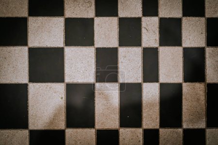 Agadir, Morocco - February 25, 2024 - Checkerboard pattern of beige and black square floor tiles