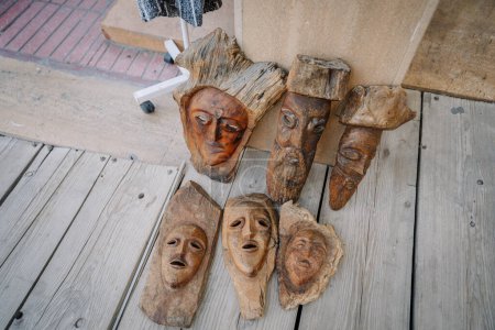 Agadir, Morocco - February 25, 2024 - Wooden carved masks laid on a boardwalk.