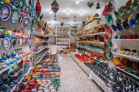 Agadir, Morocco - February 25, 2024 - A colorful ceramic shop with various dishes, pots, and decorative items on shelves.