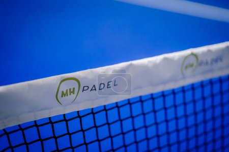 Photo for Riga, Latvia - March 3, 2024 - A close-up of a padel net with the logo "MH PADEL" on its white band against a blue court background. - Royalty Free Image
