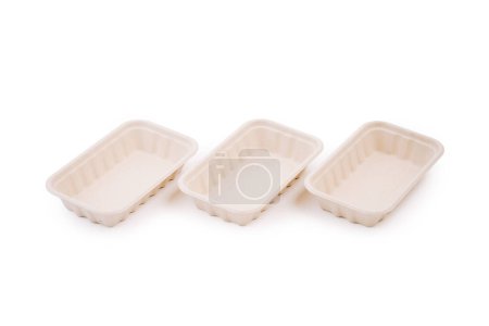 Drei rechteckige Lebensmittelschalen aus Pappe stehen nebeneinander auf weißem Hintergrund.