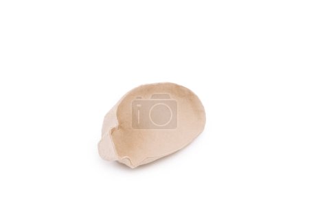 A beige bread-shaped object, the inner shape of a cardboard shoe, so as not to lose the shape of the shoe, on a white background.
