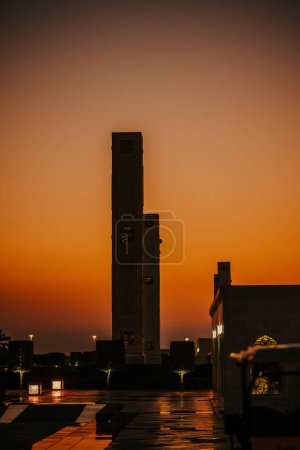 Dubaï, Émirats arabes unis - 19 octobre 2019 - Grand minaret au coucher du soleil, sculptures complexes, lanternes lumineuses, jardin serein, sentier réfléchissant.