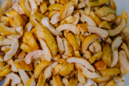 Close-up of dried quince slices, showcasing their textured, golden appearance.