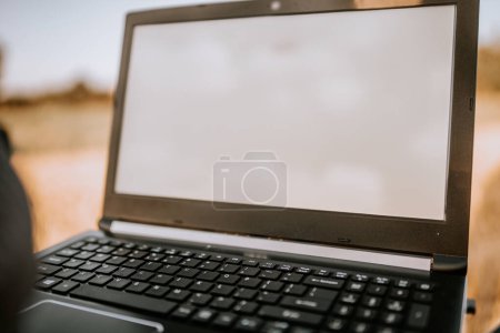 Photo for Valmiera, Latvia - August 17, 2024 - Close-up of an open laptop with a blank screen, set against an outdoor, blurred background. - Royalty Free Image