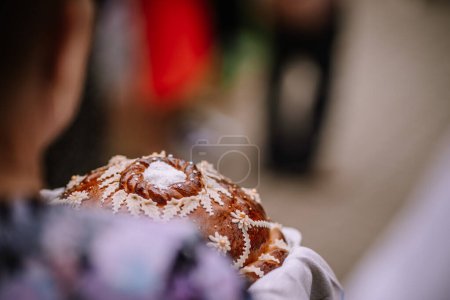 Valmiera, Latvia - August 5, 2023 - Close-up of a beautifully crafted bread with white decorative details and sugar on top, traditionally used in ceremonies or celebrations.