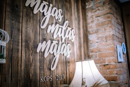 Téléchargez les photos : Valmiera, Lettonie - 10 août 2023 - un mur en bois avec le mot "majs" dans un script cursif, découpé attaché trois fois, et le texte "KOP 2019" sous - en image libre de droit