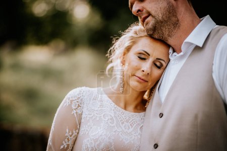 Valmiera, Lettland - 10. August 2023 - Eine Braut legt ihren Kopf mit geschlossenen Augen auf die Schulter des Bräutigams und zeigt Vertrauen und Zuneigung.