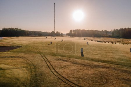 Téléchargez les photos : Valmiera, Lettonie - 12 août 2023 -bDawn illumine un terrain de golf givré avec un ciel dégagé et un paysage serein. - en image libre de droit