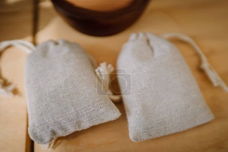 Dobele, Latvia - August 18, 2023 - Two linen drawstring pouches on wooden surface.