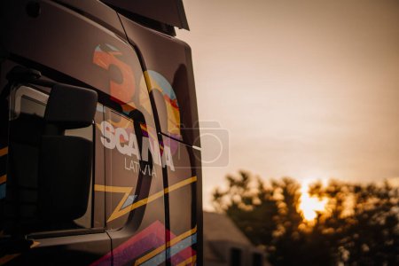 Dobele, Lettland - 18. August 2023 - Nahaufnahme eines Lastwagens mit der Aufschrift "SCANIA LATVIA" bei Sonnenuntergang mit Bäumen im Hintergrund.