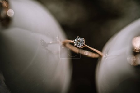 Foto de Valmiera, Letonia - 19 de agosto de 2023 - Macro disparo de un anillo de compromiso de diamantes delicadamente colocado en una superficie blanca y brillante, destacando el diseño intrincado y el brillo del diamante. - Imagen libre de derechos