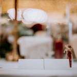 Valmiera, Latvia - August 19, 2023 - Close-up view of a wedding table setting featuring an open menu card in focus with a blurry, bokeh-lit background of the reception.
