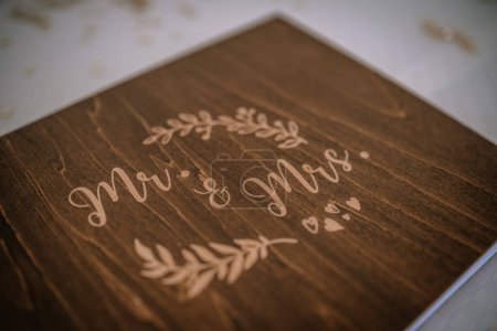 Valmiera, Latvia - August 19, 2023 - A close-up view of a wooden plaque engraved with "Mr. & Mrs." surrounded by a floral wreath design.