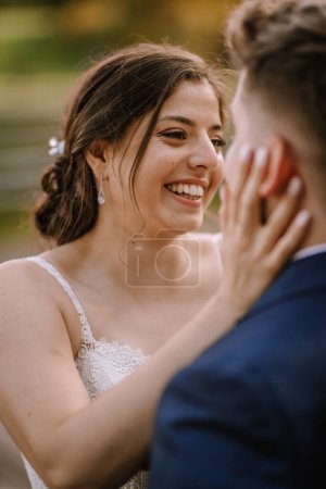 Photo for Valmiera, Latvia - August 19, 2023 - Bride joyfully touching groom's face, both sharing a close moment, her smile wide and eyes gleaming with happiness. - Royalty Free Image