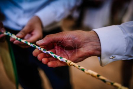 Valmiera, Lettland - 19. August 2023 - Nahaufnahme von Händen, die ein geflochtenes Seil halten, mit Fokus auf die Textur und Farben des Seils.