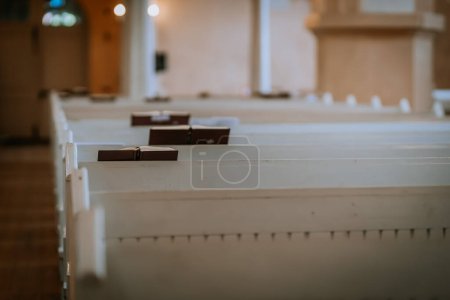Valmiera, Lettland - 12. Mai 2024 - Kirchenbänke mit Gesangbüchern in einer ruhigen und leeren Kapelle.