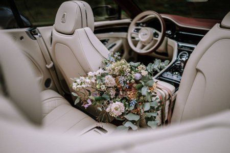 Photo for Riga, Latvia, - August 26, 2024 -  a luxury car's interior with a floral bouquet on the rear seat. - Royalty Free Image