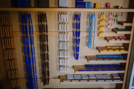 Téléchargez les photos : Valmiera, Lettonie - 22 mai 2024 - Perles Montessori de différentes couleurs et longueurs disposées sur des étagères dans une salle de classe. Les perles sont utilisées pour le comptage éducatif et les activités mathématiques. - en image libre de droit