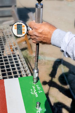 Téléchargez les photos : Paint inspector is testing pull-off adhesion (dolly) test for coating. This measured pull-off force provides a direct indication of the strength of adhesion between the coating and the substrate. - en image libre de droit