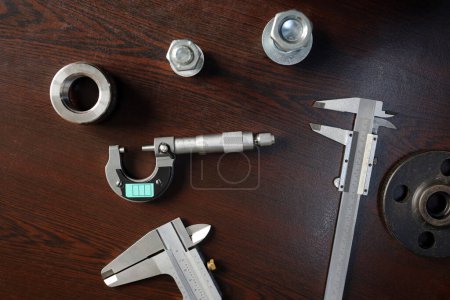 Foto de Vista del medidor de micrómetro de bola, medidores de micrómetro de pinza y materiales de acero sobre la mesa. - Imagen libre de derechos