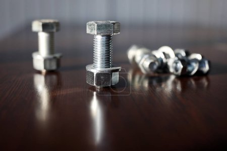 Photo for A lot of metal bolts, nuts and washers. Bolts are for the assembly of two unthreaded components, with the aid of a nut. Screws in contrast are used in components which contain their own thread. - Royalty Free Image