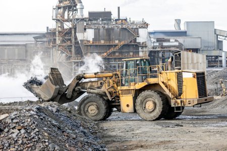 Téléchargez les photos : The big bulldozer and industrial pollution. Pollution is the introduction of contaminants into the natural environment that cause adverse change. - en image libre de droit