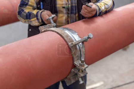 Photo for Workers are pipe fitting adjustment (fit-up) with clamps before welding. - Royalty Free Image