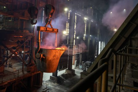 Photo for View of the big induction furnace and melting pot in foundry for smelting. The ores of base metals are often sulfides. In recent centuries, reverberatory furnaces have been used to keep the charge. - Royalty Free Image