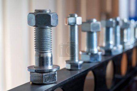Photo for View of the bolts and nuts (fasteners). A bolt is a form of threaded fastener with an external male thread. Bolts are very closely related to screws. Bolts are often used to make a bolted joint. - Royalty Free Image