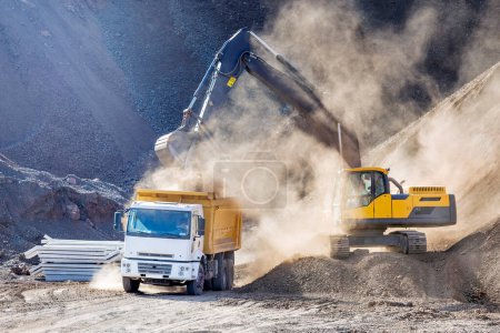 Foto de Las excavadoras están excavando y cargando a un camión en el sitio de construcción. - Imagen libre de derechos