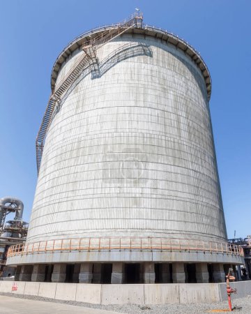 Téléchargez les photos : Vue du réservoir d'ammoniac cylindrique vertical à double paroi et de la tuyauterie industrielle. Dans les industries des engrais, l'ammoniac excédentaire est stocké dans un réservoir de grande capacité. - en image libre de droit
