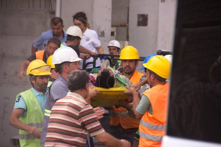 Foto de Estambul, TURQUÍA - 30 DE SEPTIEMBRE DE 2018: Accidente industrial en la obra. Trabajador lesionado transportado en camilla. - Imagen libre de derechos