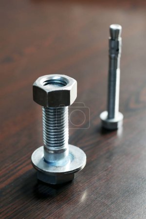 Photo for View of the bolt, nut and washer (fasteners). Bolts are for the assembly of two unthreaded components, with the aid of a nut. Screws in contrast are used in components which contain their own thread. - Royalty Free Image