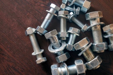Photo for View of the bolt, nut and washer (fasteners). Bolts are for the assembly of two unthreaded components, with the aid of a nut. Screws in contrast are used in components which contain their own thread. - Royalty Free Image