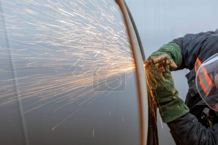 Foto de The worker is cutting to metal plate with manual flame cutting process. Oxy-fuel welding, oxyacetylene welding, oxy welding, or gas welding and oxy-fuel cutting are processes that use fuel gases. - Imagen libre de derechos
