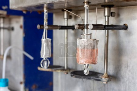 Photo for Electrolysis of copper sulfate in lab. It takes place in an electrolytic cell where electrolysis which uses direct electric current to dissolve a copper rod and transport the copper ions to the item. - Royalty Free Image