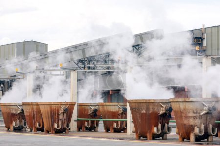 Téléchargez les photos : Grande fonderie rustique coulée creuset casseroles de fusion. Des scories chaudes dans le creuset de l'usine de traitement du cuivre. Le laitier de cuivre est un sous-produit de l'extraction du cuivre par fusion et de la fumée dans l'usine, l'industrie - en image libre de droit