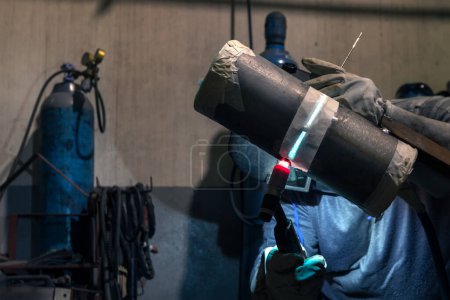Photo for Welder qualification testing with gas tungsten arc welding (gtaw, argon) process of the stainless steel pipe. Welder certification is based on specially designed tests to determine a welder's skill. - Royalty Free Image