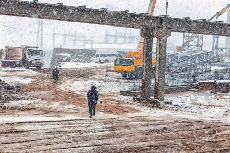 Foto de Paisaje del sitio de construcción mientras nieve.Construcción de casas de hormigón en la nieve - Imagen libre de derechos