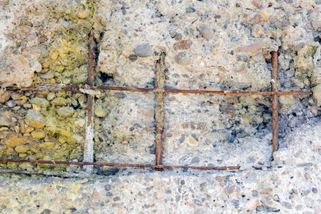 Photo for View of the corrosion of reinforcement bars. The flat fragments of concrete are detached from the concrete mass by the rebars corrosion and may fall down. - Royalty Free Image