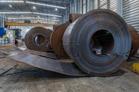 Téléchargez les photos : Vue des bobines de tôles d'acier au carbone laminées à chaud pour fabriquer des tubes soudés en spirale (bandes, rouleaux, feuilles) dans l'usine métallique. - en image libre de droit